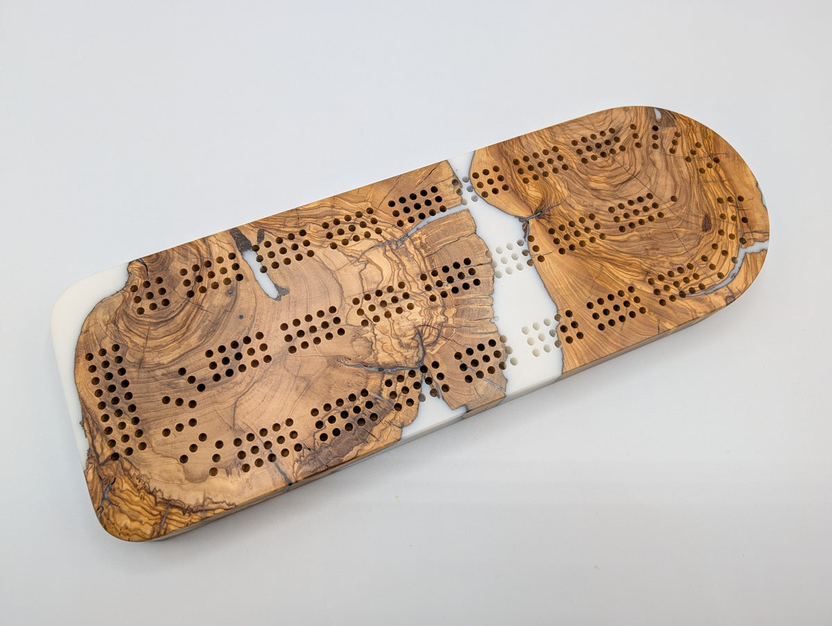 Ivory Crossing Origin Turkish olivewood cribbage board with white resin — playing face.