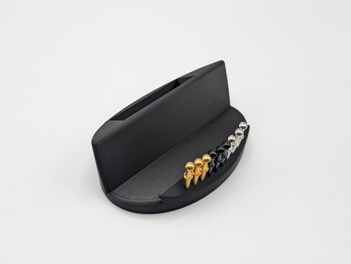 Included Derevo display stand with integrated peg storage and space for playing cards.
