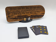 Bocote cribbage board with bold grain, displayed with its stand, pegs and playing cards.