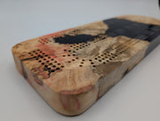 Ember Current Origin Manitoba maple burl cribbage board with smoky midnight blue resin — close-up of wood, resin and playing tracks.