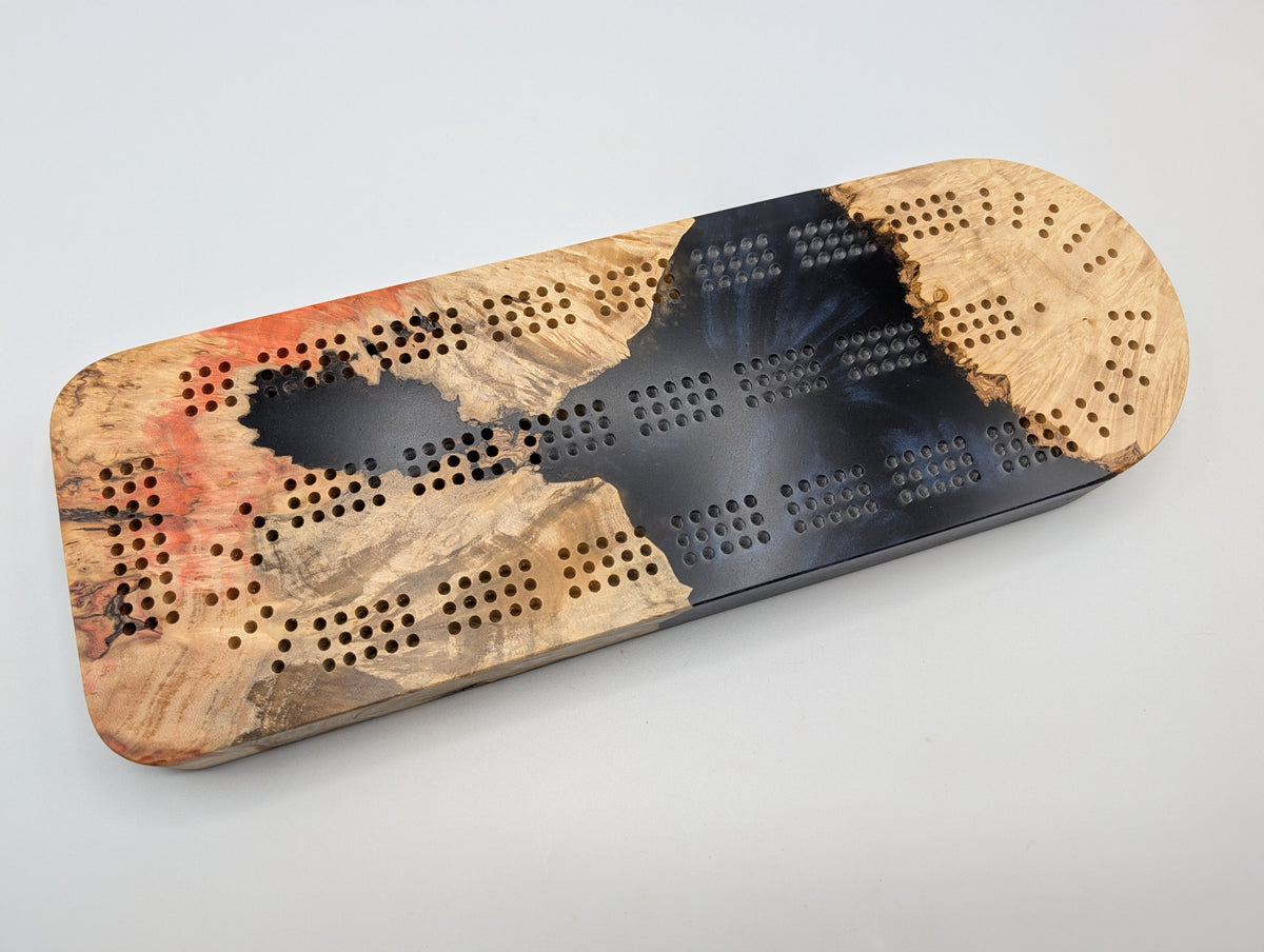 Ember Current Origin Manitoba maple burl cribbage board with smoky midnight blue resin — playing face.