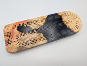 Ember Current Origin Manitoba maple burl cribbage board with smoky midnight blue resin — playing face.