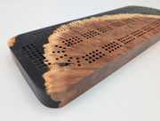 Midnight Shore Origin red mallee burl cribbage board with smoky black resin — close-up of wood, resin and playing tracks.