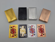 Four waterproof playing-card decks in gold, black, silver and rose gold, with matching foil-finished cards shown beneath the boxes.