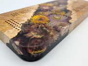 One-of-a-kind Imprint brown mallee burl cribbage board with real strawflowers in yellow, cream and purple, close-up of the inlay, burl grain and playing holes.